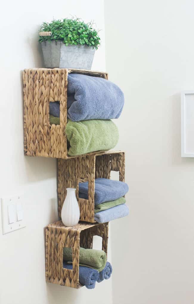 baskets mounted to wall with bath towels and decor