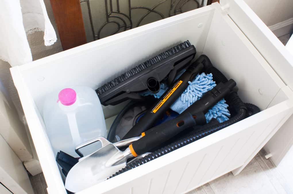 Inside the IKEA Silveran white storage bench filled with Homeright Steam Cleaner and accessories