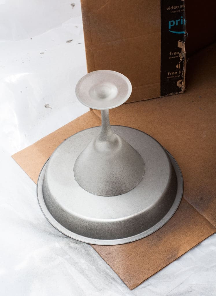 cake pan with glass attached to bottom sitting on cardboard flap