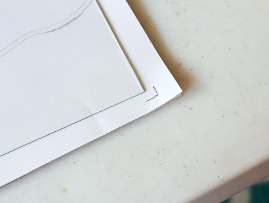 paper and glass sitting on table with pencil marks