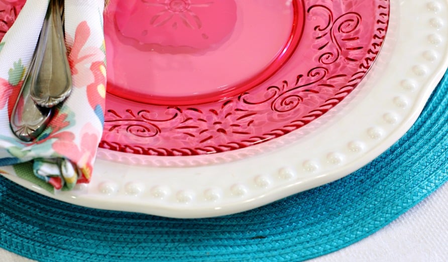 tablesetting on table with white tablecloth teal placemat pink and white dish