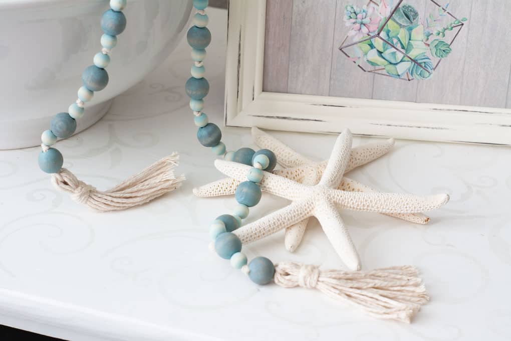 starfish with aqua wooden beads and tassels sitting on white table