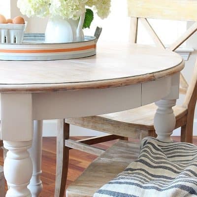 white farmhouse table and chair with tray and pitcher with flowers striped seat cushion