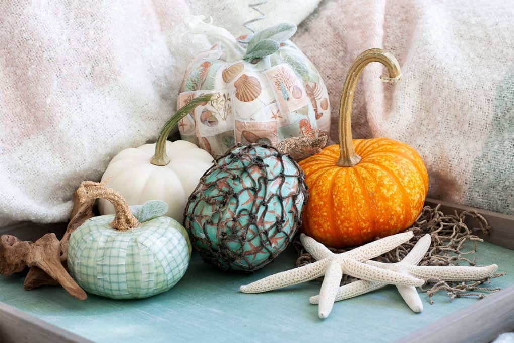 diy mod podge pumpkins coastal style pumpkins with coastal pattern and leaves and stem on tray with starfish and blanket in background