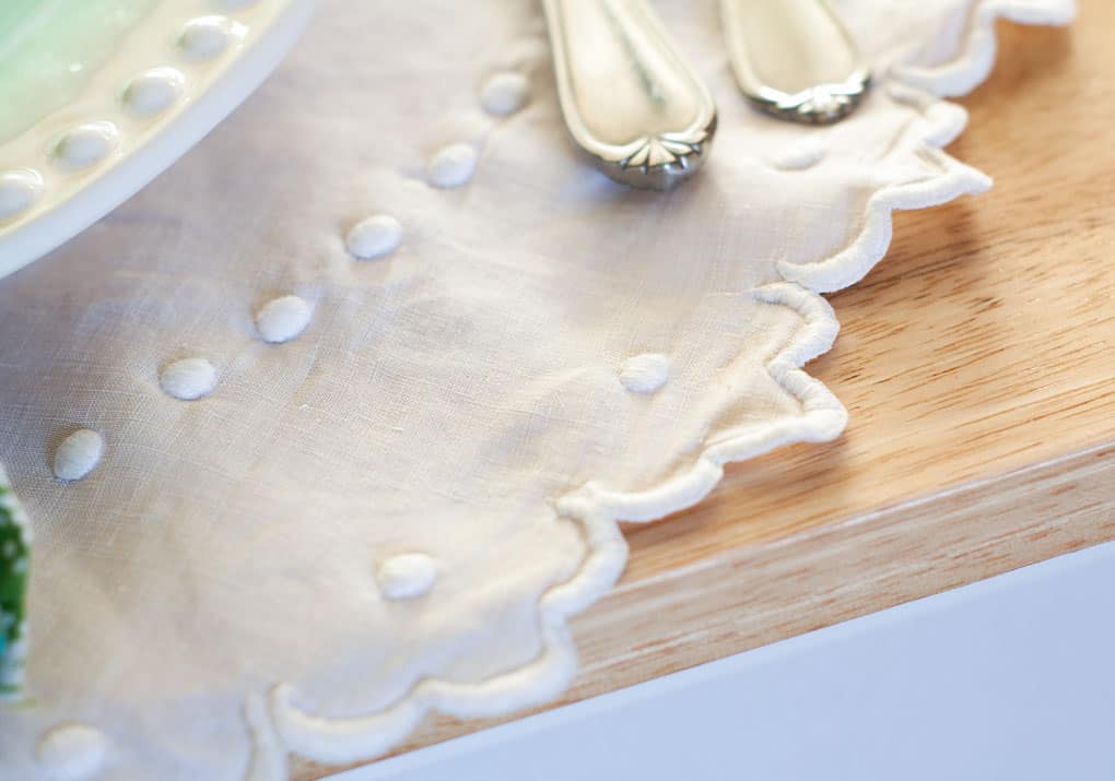 7 elements for a single fall tablescape table for one #2 embroidered linen with silverware on a wood surface