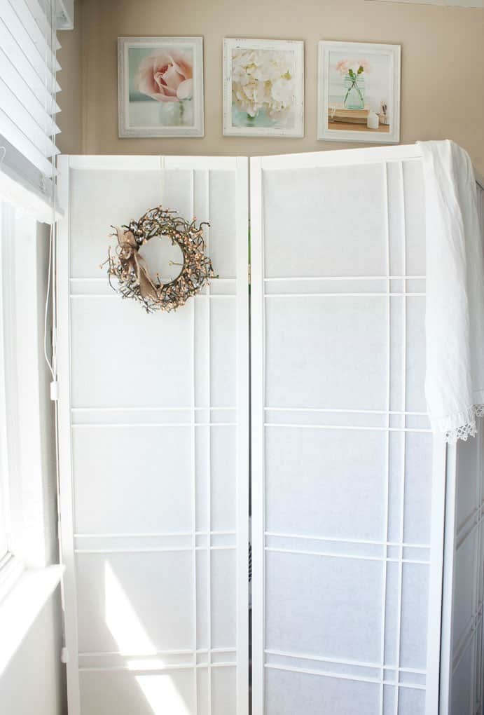 add quick and easy extra closet to any room room divider near window with floral photos in frames above on wall