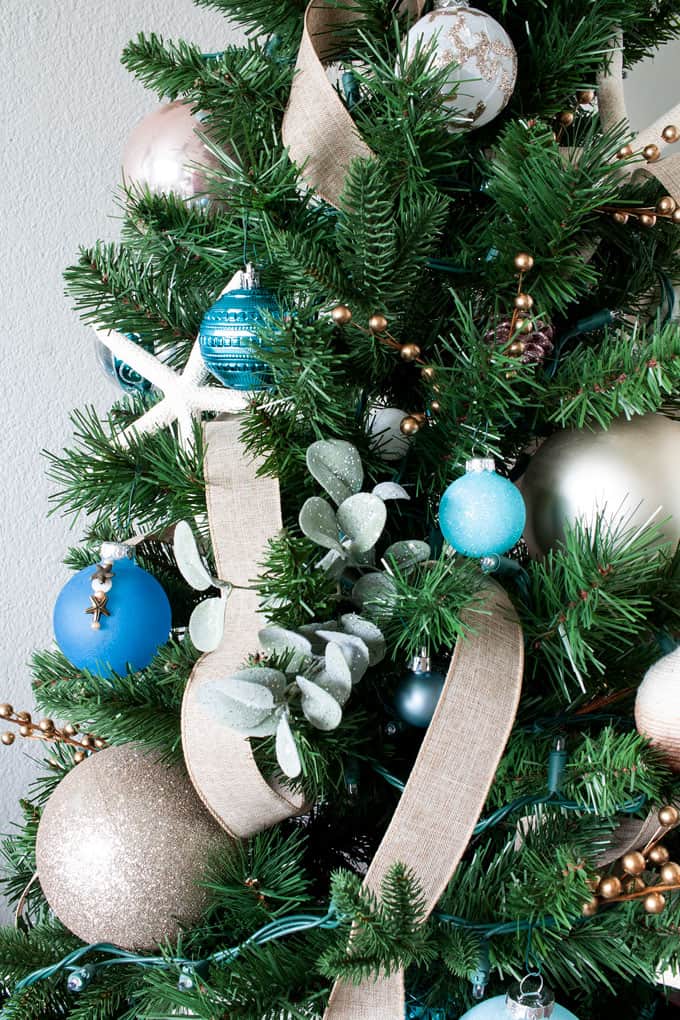 big ideas for decorating a small christmas tree with coastal ornaments and ribbon