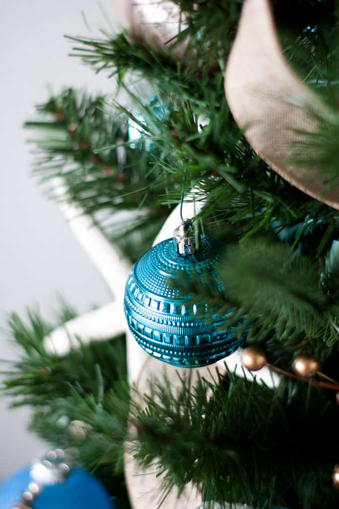 big ideas for decorating a small christmas tree with teal ornament and starfish in background