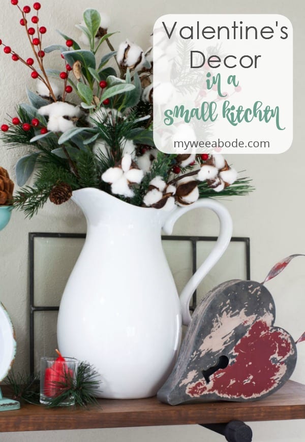 winter-valentine-decor-small-kitchen open shelving with scale white pitchers pine cones and greenery