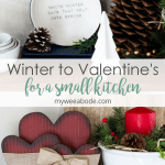 winter-valentine-decor-small-kitchen red wooden hearts and bow wiht white bowl and red candle with greenery and berries on wood surface