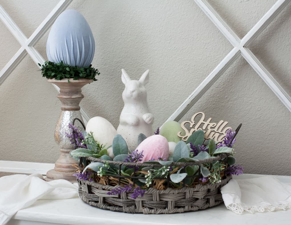 how to make velvet easter eggs vignette with candle holder and velvet egg with basket bunny lambs ear florals on white surface with window pane in background