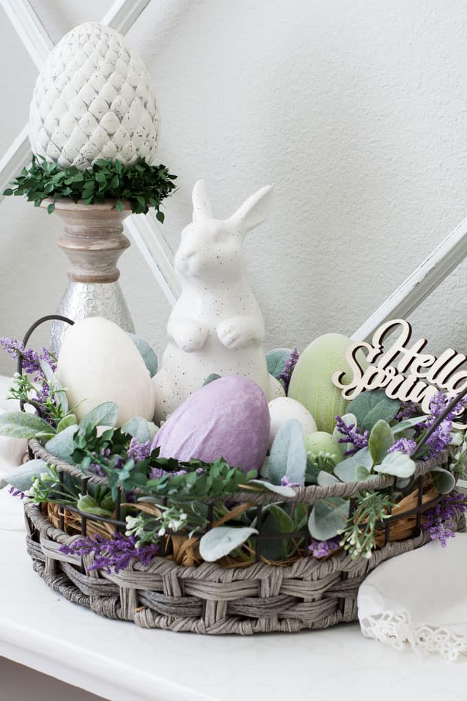 spring decorating ideas using velvet easter eggs vignette with candle holder and velvet egg with basket bunny lambs ear florals on white surface with window pane in background