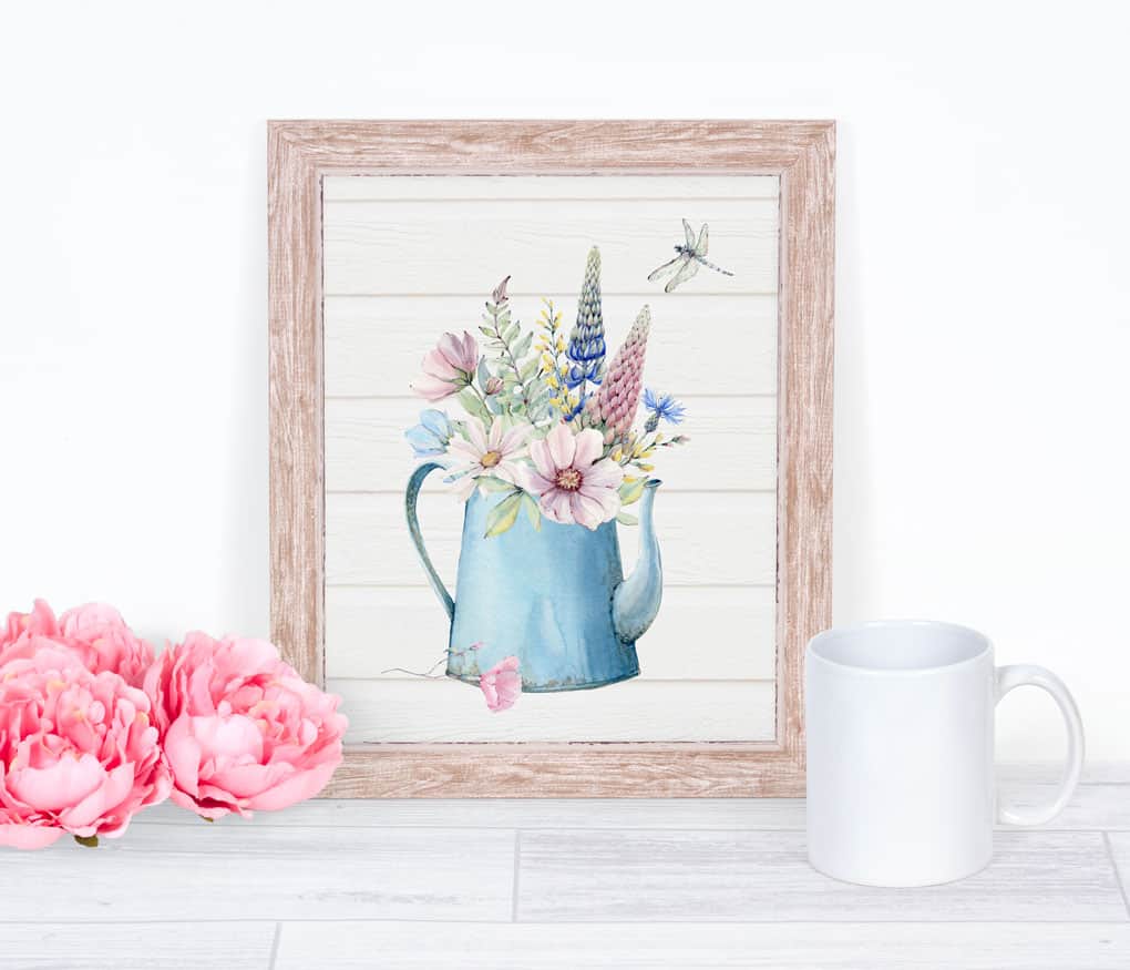 free spring watercolor wall art watering can with spring flowers on surface with pink flowers and coffee mug