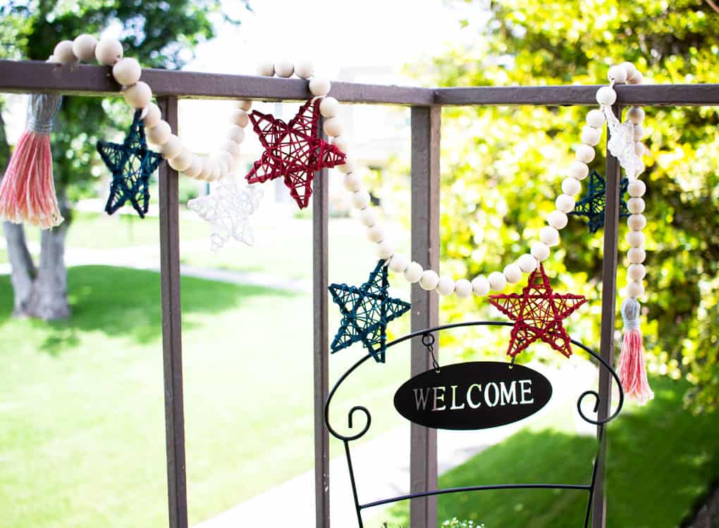 small porch decor red white blue wood bead garland with stars and stair railing outside