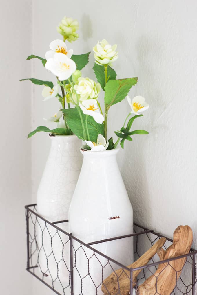 create temporary accent wall mill bottle in racks with flowers and driftwood