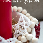 diy wood bead garland stars in white bowl with red candle