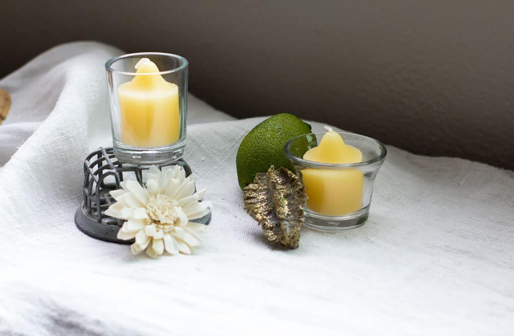yellow votive candles with dried flowers on linen cloth