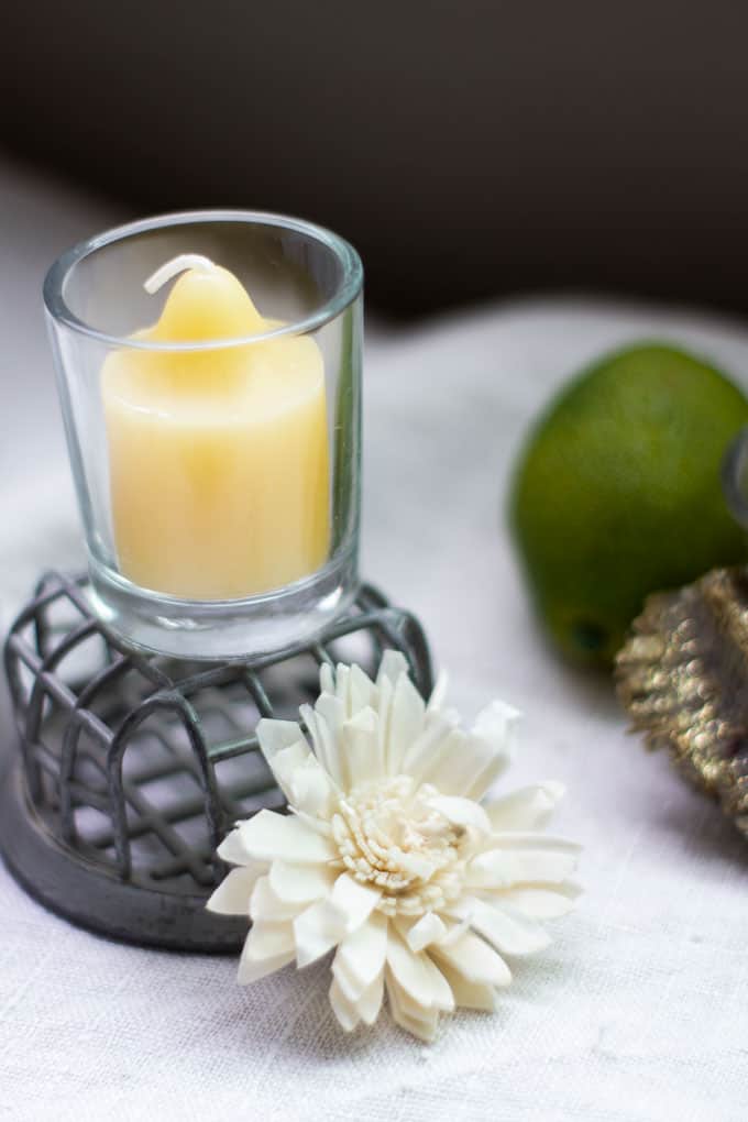 yellow votive candles with dried flowers on linen cloth