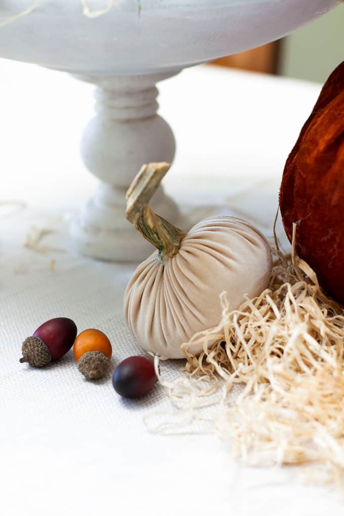 thanksgiving centerpiece with velvet pumpkins straw and acorns
