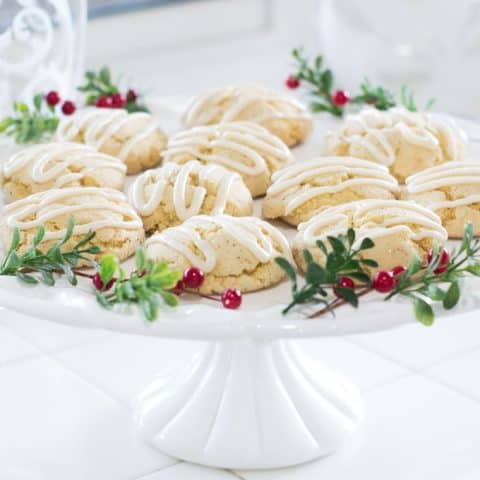 easy holiday nutmeg cookies on cake plate with berries and greenery