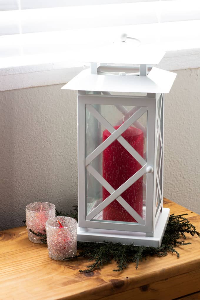how to make a valentine garland with velvet covered hearts hanging on a wooden window bench with white lantern and votives