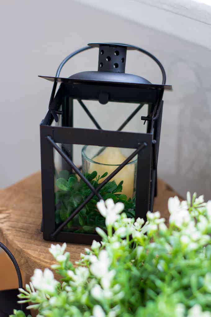 refresh your mantel with spring decor black lanterns with white pot and boxwood on wood surface