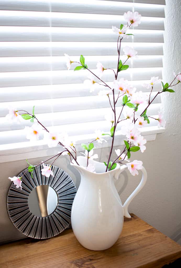 refresh your mantel with spring decor white pitcher with pink blossoms and mirror on window bench