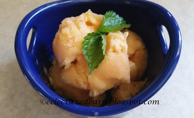 peach sorbet in blue bowl with mint sprig