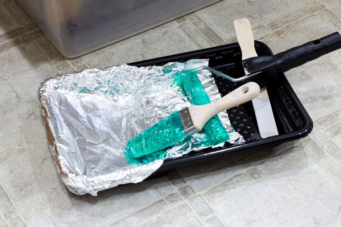 painting tray with brushes wrapped in plastic wrap