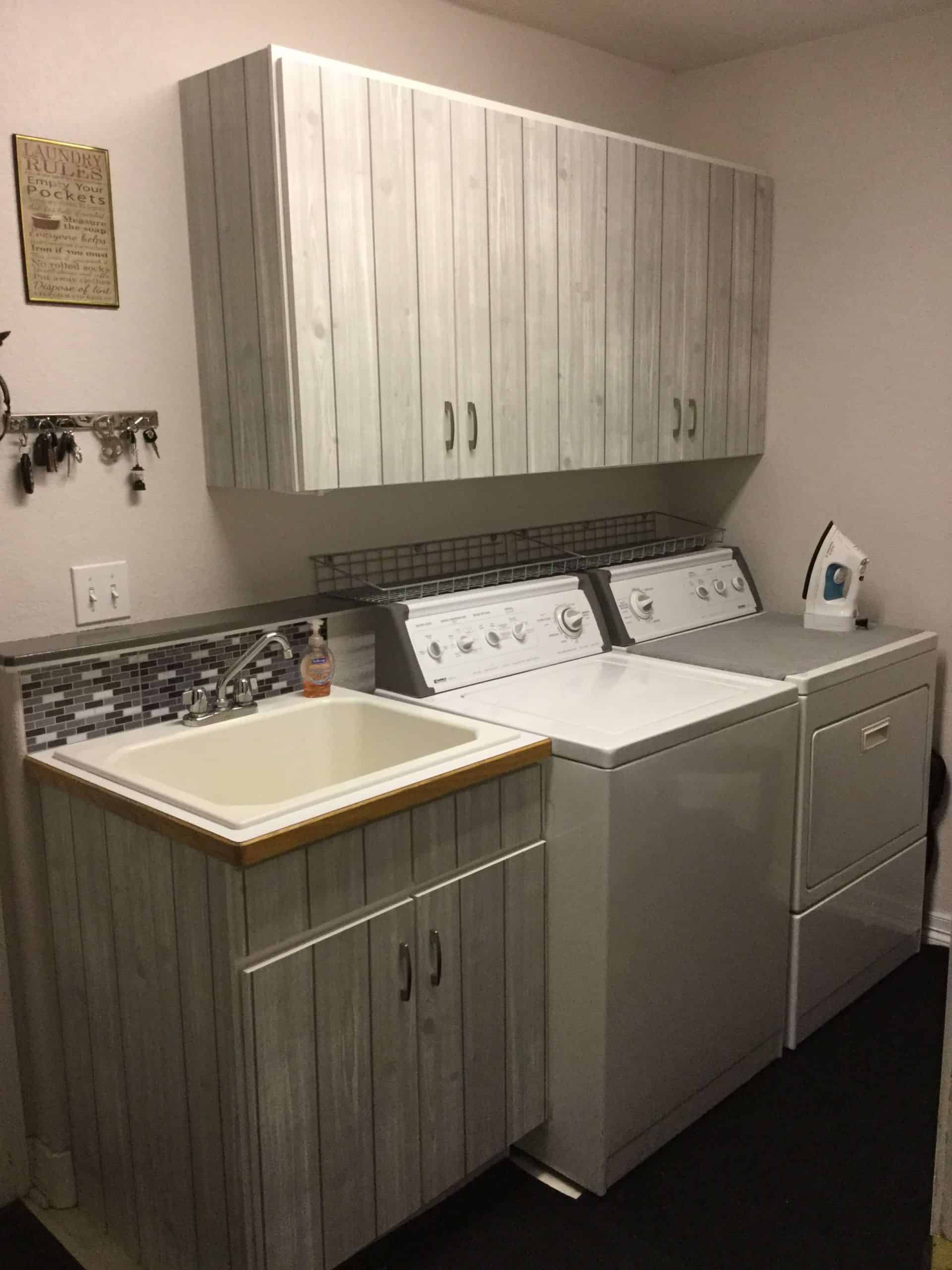 laundry room in gray and white with faux wood cabinets