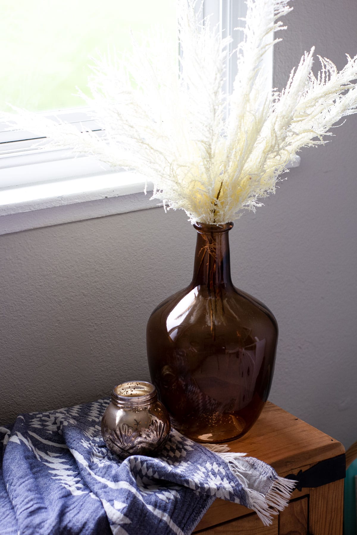 easy fall decor ideas amber demijohn with ivory stems on a window bench