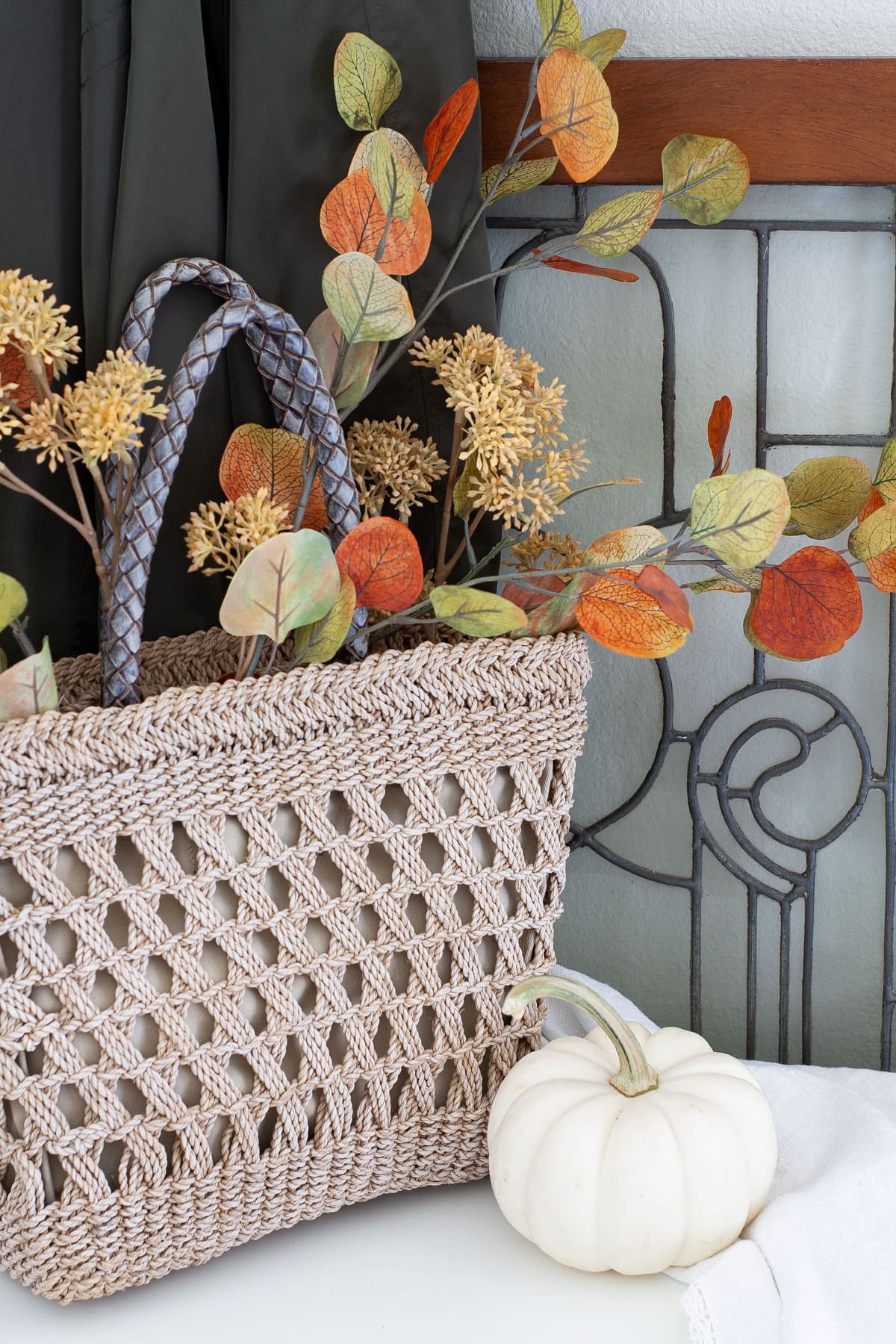fall apartment entryway decor straw tote with branches and pumpkin