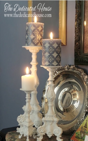 white candle holders with lit candles on mantel