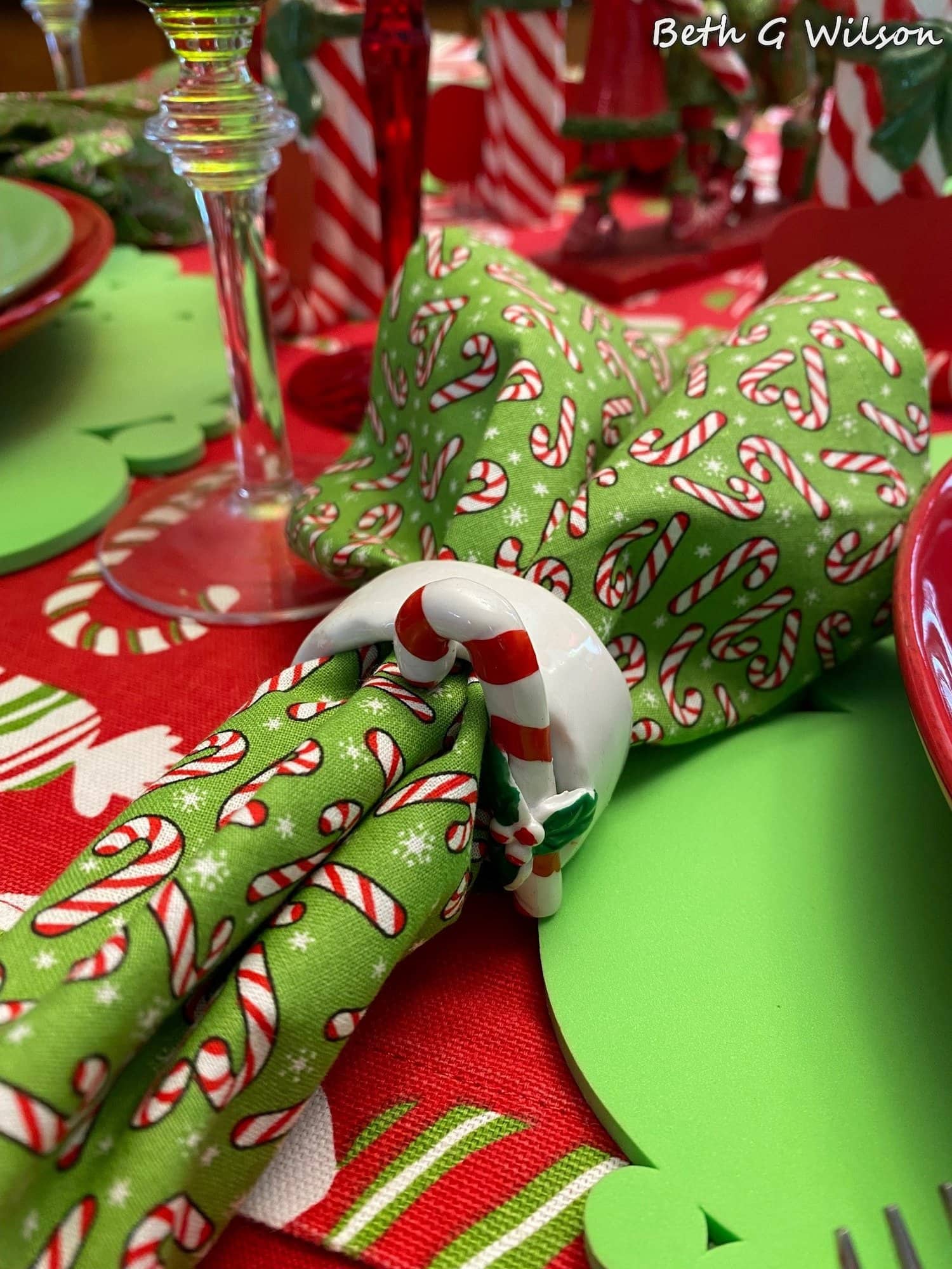 candy cane napkin in candy cane ring with green and red accents