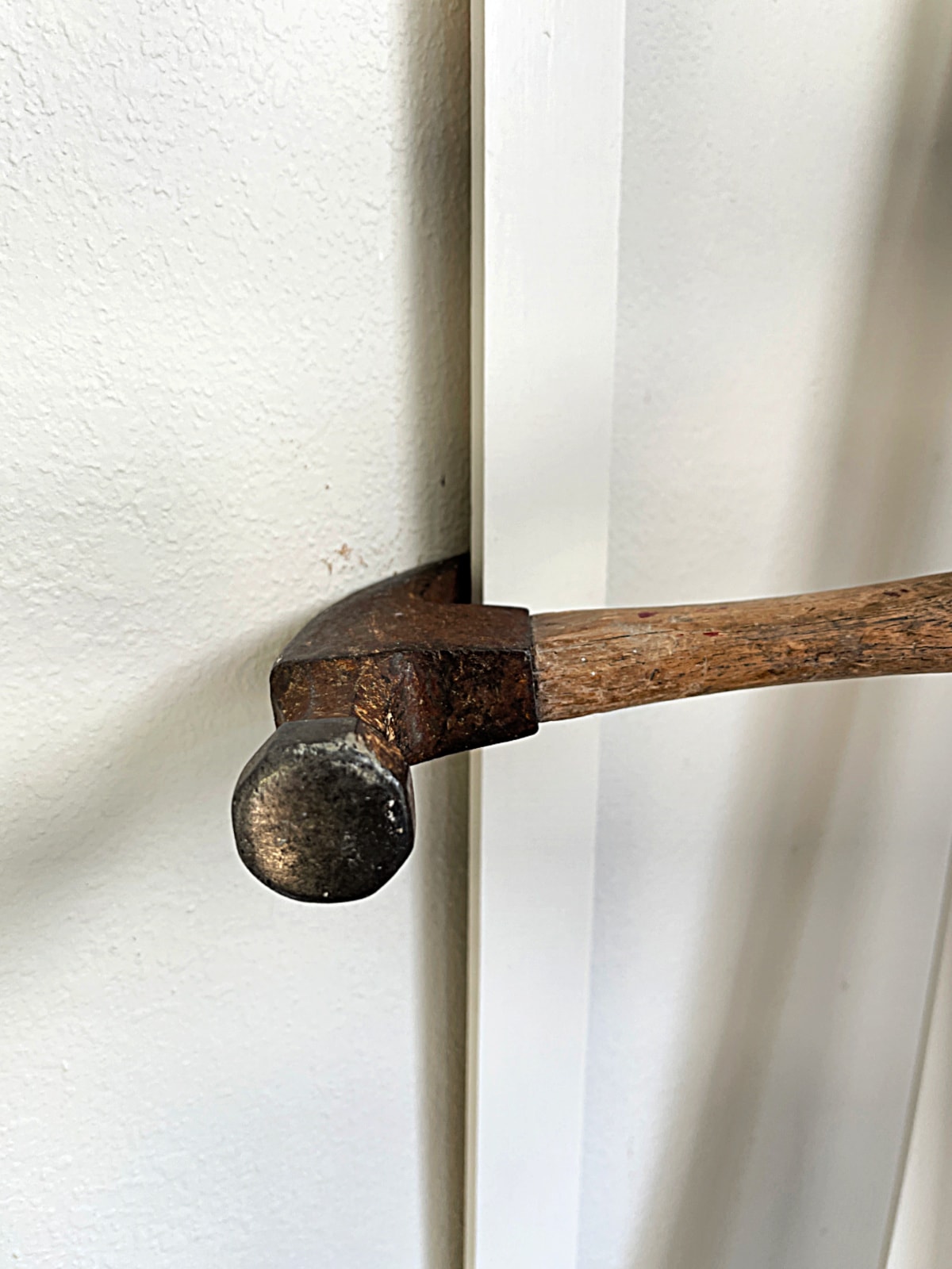 hammer removing wood trim from wall
