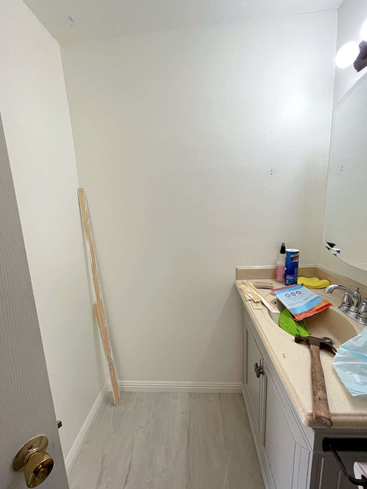bathroom with blank wall and counter with cleaning and construction tools