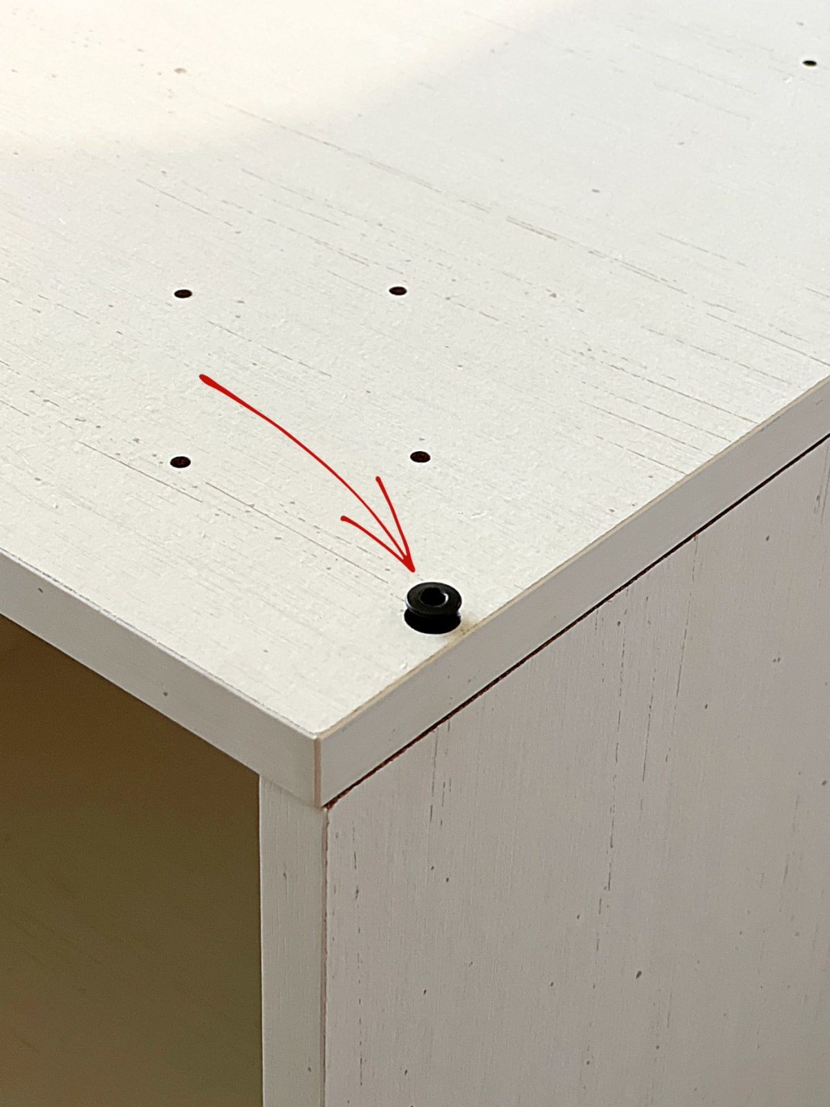 furniture piece with screw halfway in hole