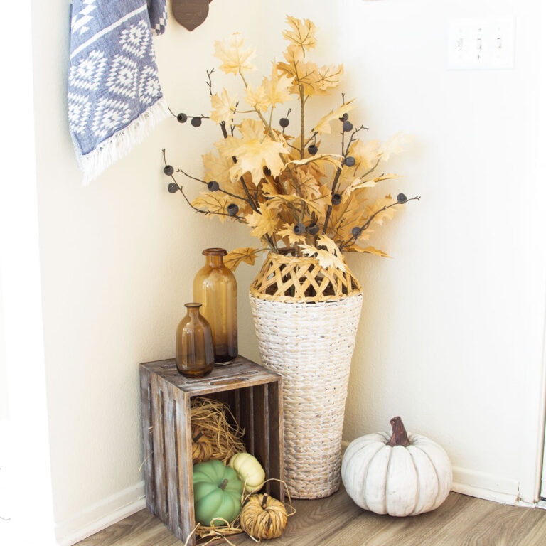tiny entryway fall decor ideas fall vignette in corner with woven vase crate with pumpkins and fall elements