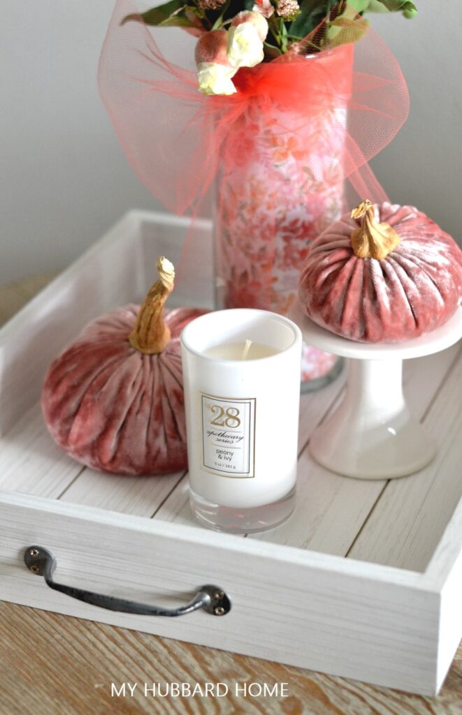 white wood tray with candles and rose colored velvet pumpkins