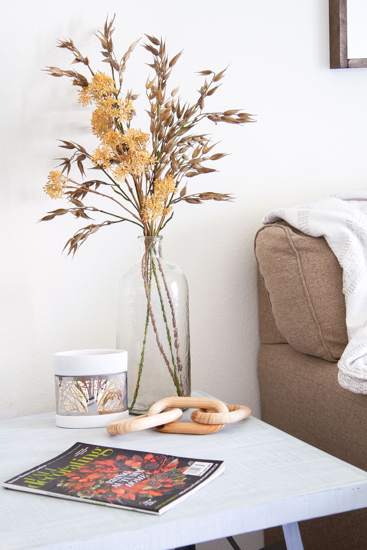 small apartment fall living room tour vase with fall stems and wooden links on gray table