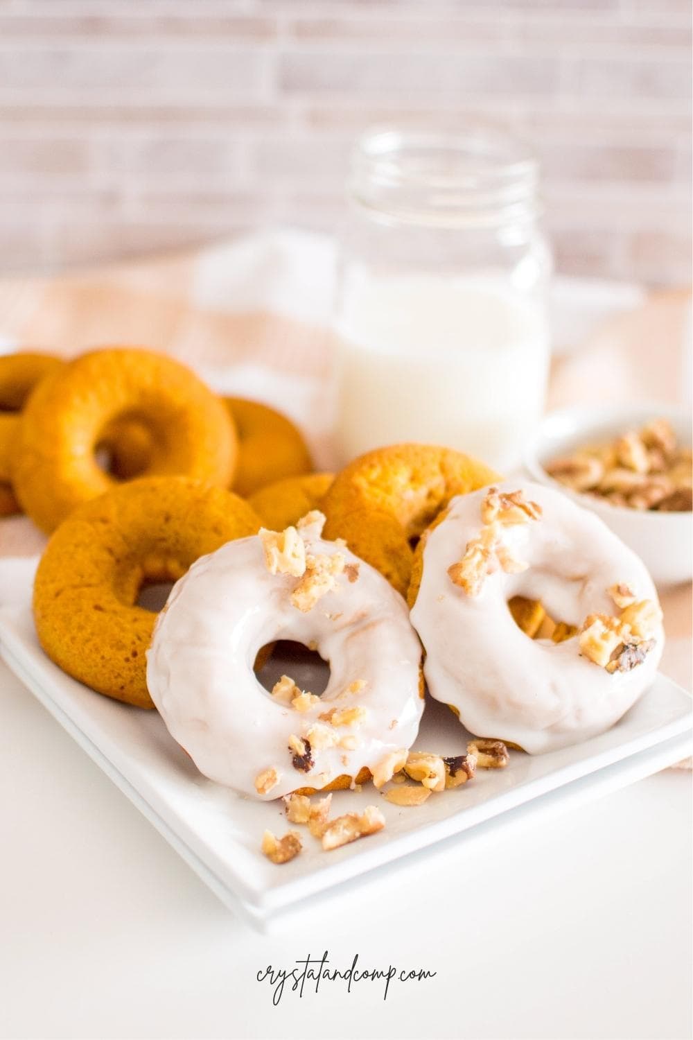 iced pumpkin donuts on white plate