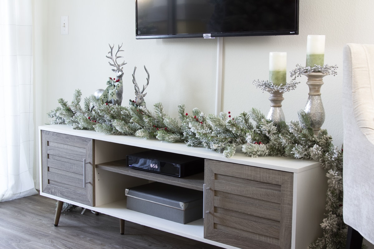 a tiny home christmas tour tv console with garland deer and candles