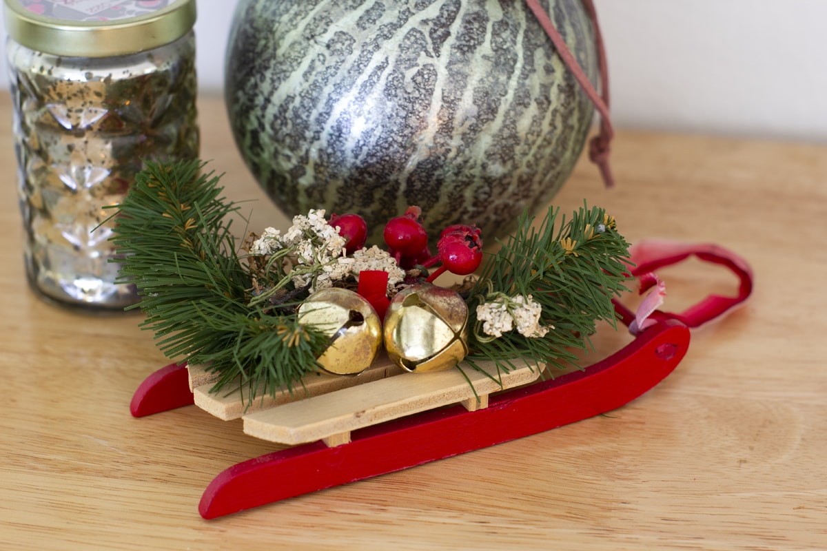 sled ornament with jingle bells and greenery