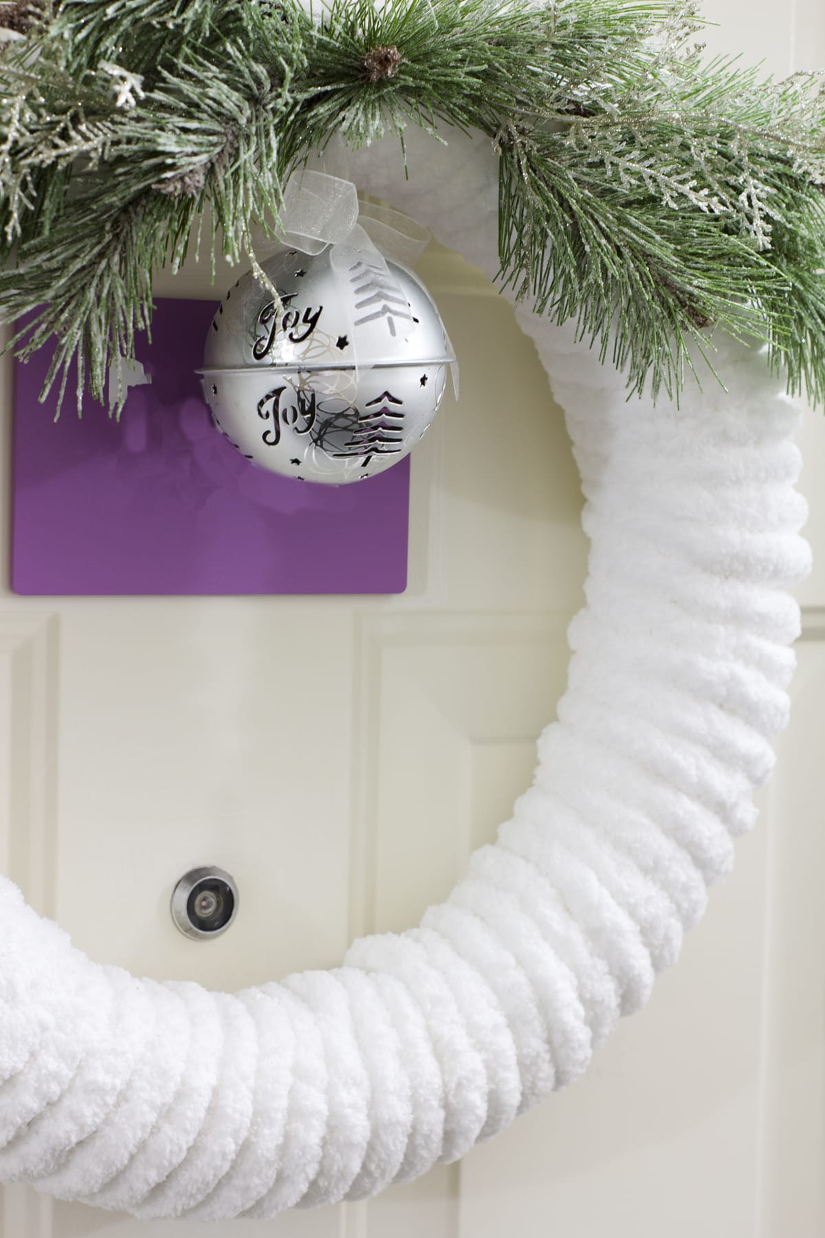 diy plush chunky yarn christmas wreath hung on apartment door