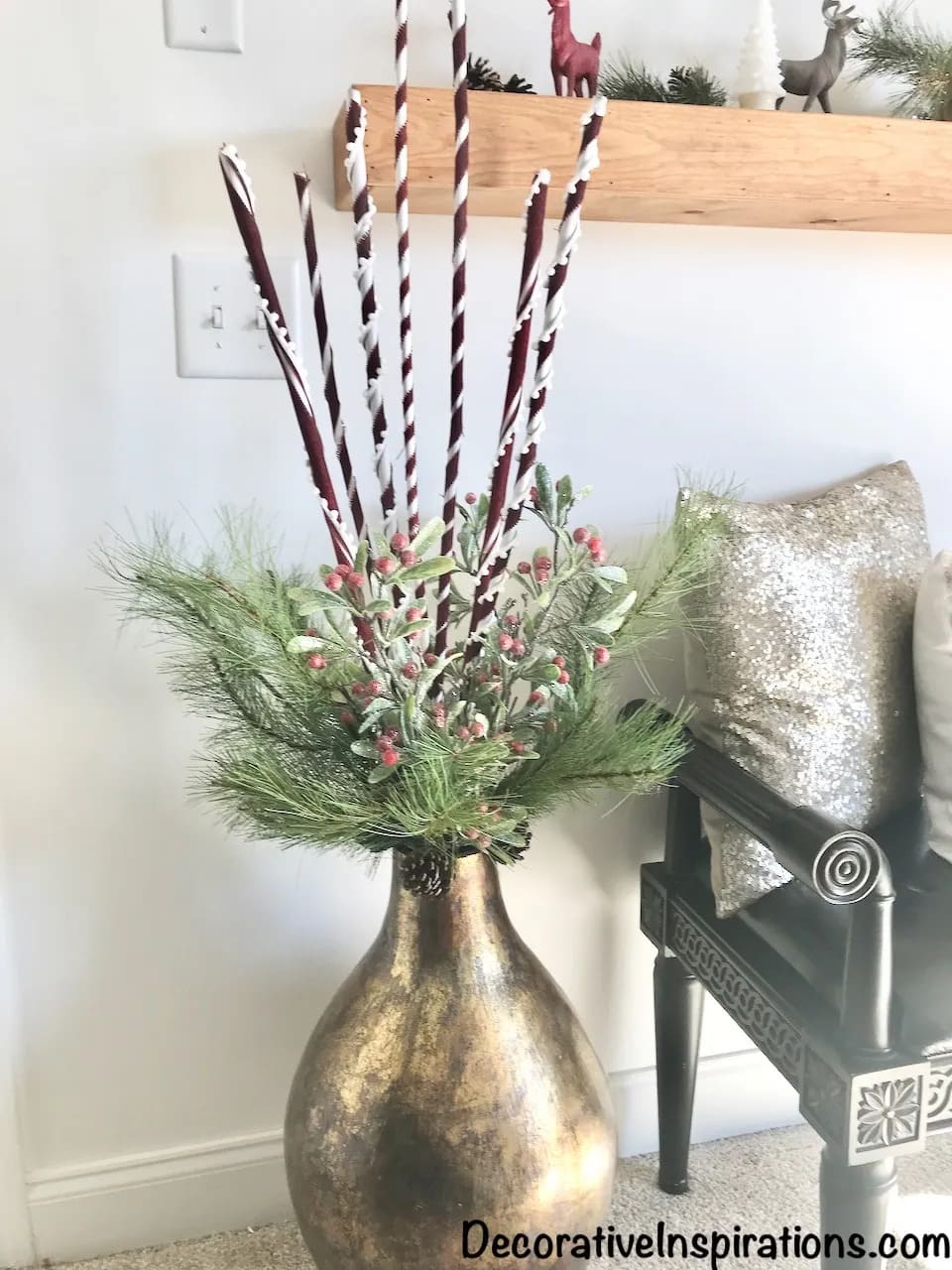gold vase with christmas greens and candy cane sticks