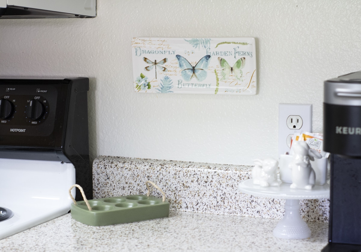 small apartment kitchen spring decor egg tray and bunnies on counter with butterfly wall plaque