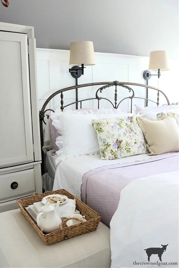 cottage style bedroom with lavender and white spring decor pillows bed tray armoire