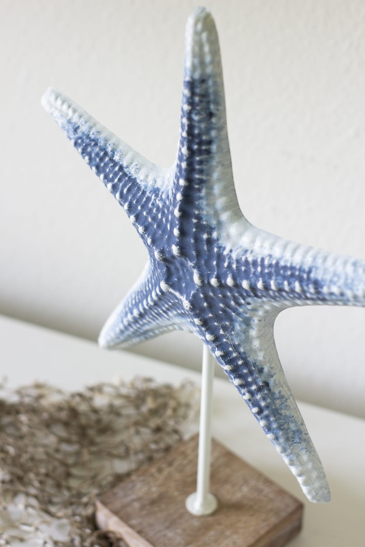 blue metal starfish on stand with fishing net at the bottom