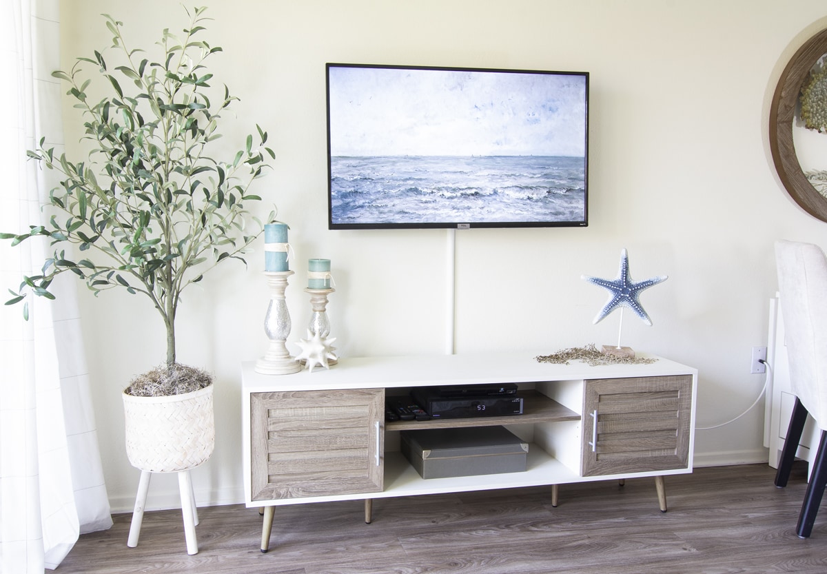 summer apartment living area with coastal decor tv console with tv art and coastal elements