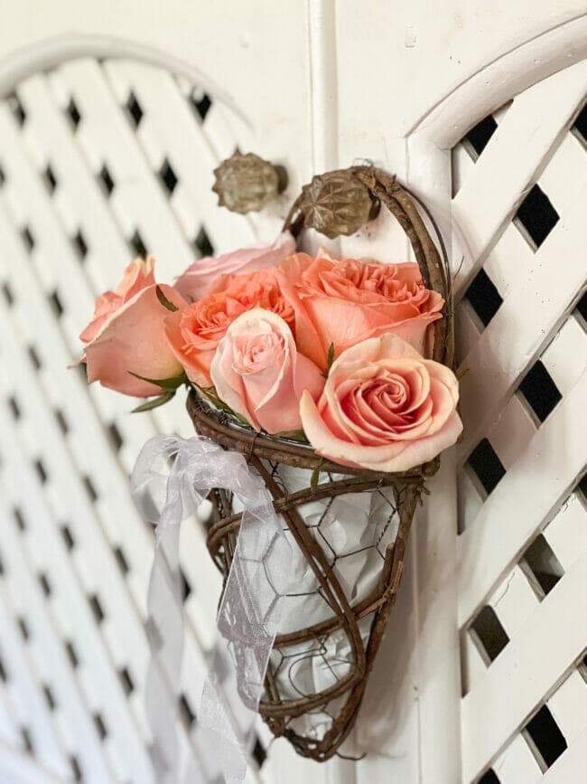 tuesday turn about 202 floral gala grapevine holder with roses hanging on handle of white lattice door